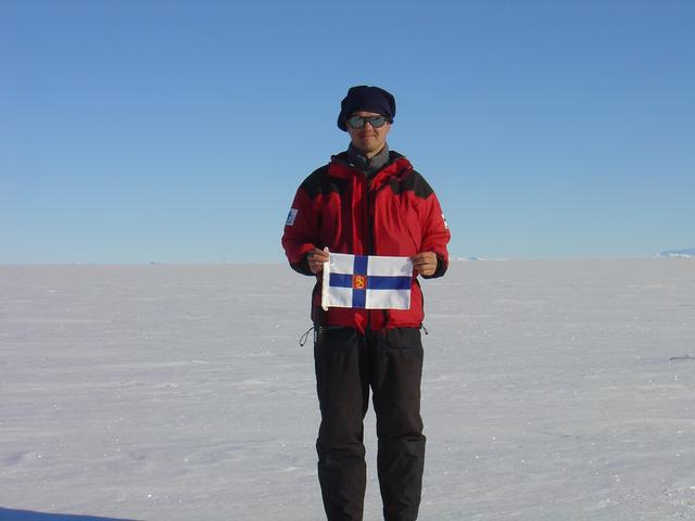 Me with flag of Finland and part of Heimefrontfjella at horizon