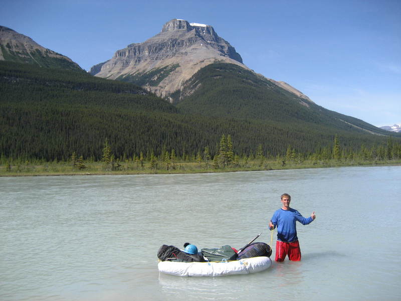 Chris using the dinghy to cross the North Saskatchewan river.  Notice the water marks up to his belly button level.
