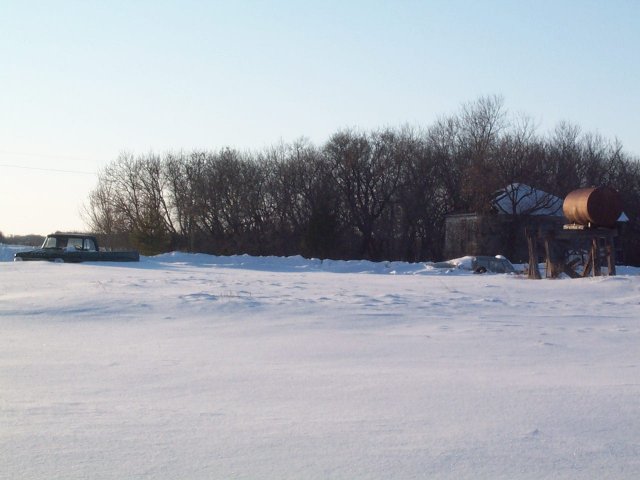 View to the West with House, Snow-Submerged Truck and Fuel Tank