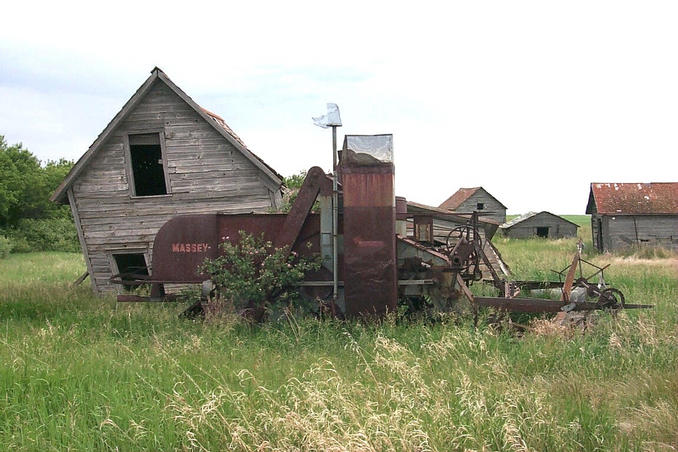 Outbuildings and machinery on the homestead. Note the wild roses growing around the machinery.