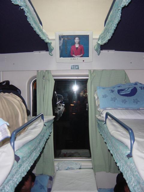 Modern hard-sleeper compartment on train from Shenzhen to Meizhou, with comfortable bunks and flat-panel video screen