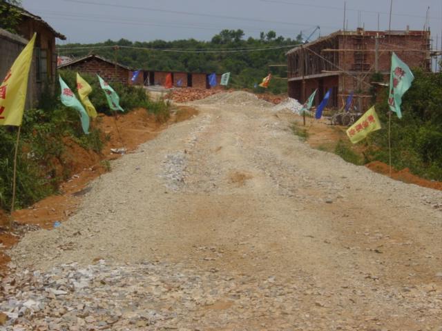 Gravel road to construction site, with confluence on top of hill behind