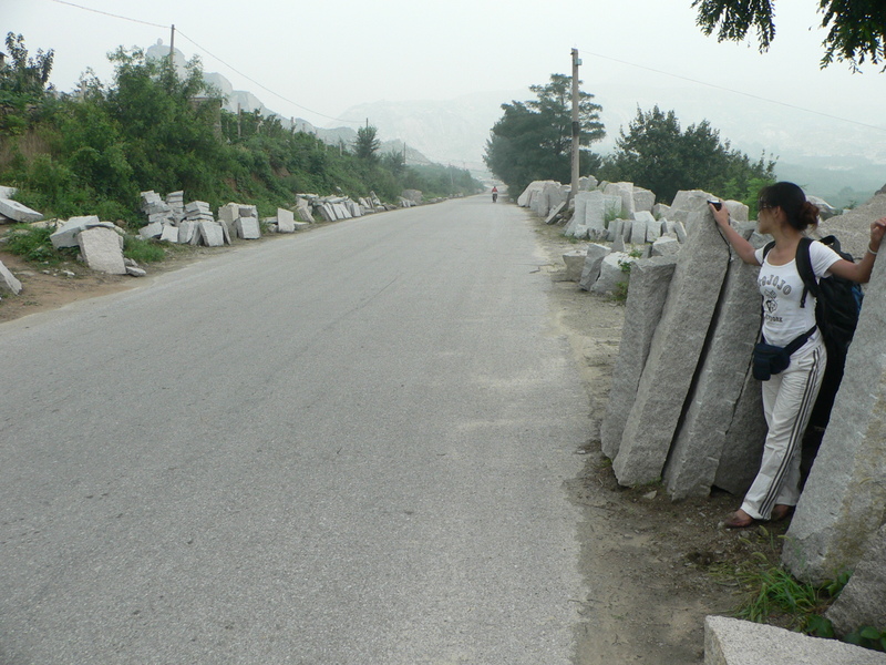 Ah Feng amid the slabs of rock littering the side of the road