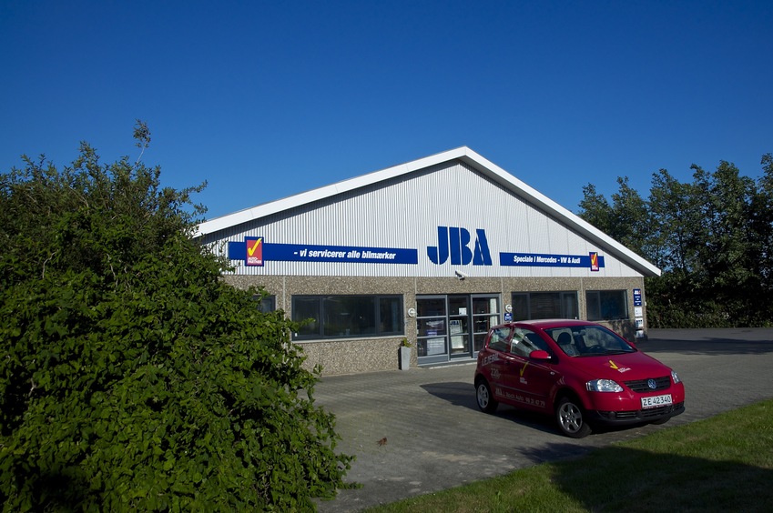 The front of the JBA ("J. Block Auto") repair business.  The confluence point lies just inside the left-hand wall (hidden behind the bush)