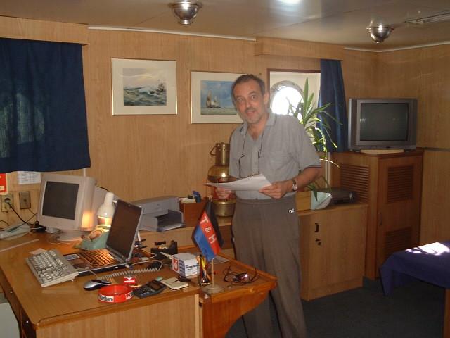 Captain Peter preparing papers in his cabin