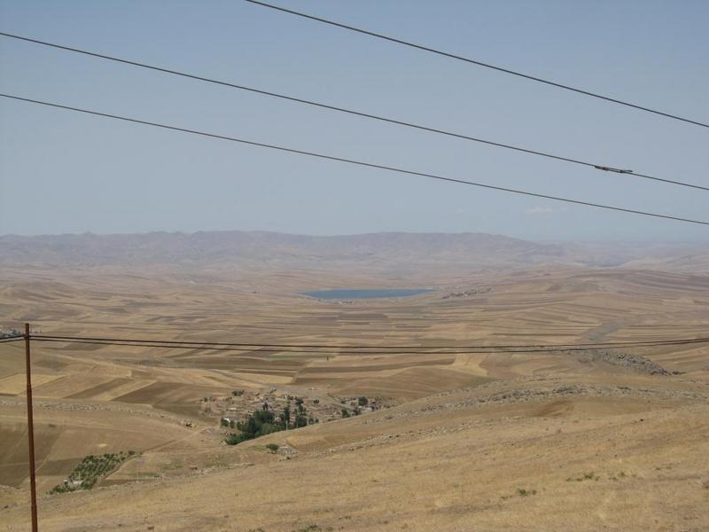 The view from higher up: farmland, villages, and a reservoir lake