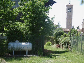 #1: The confluence point is at the corner of the house, behind the gas tank (seen from the east). Background: church of San Lorenzo
