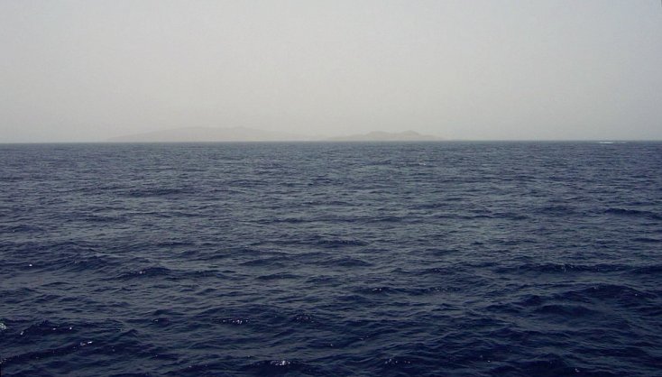 View looking SE at 25N 37E with reef break waves and distant Hasāniyy and Libāna Islands