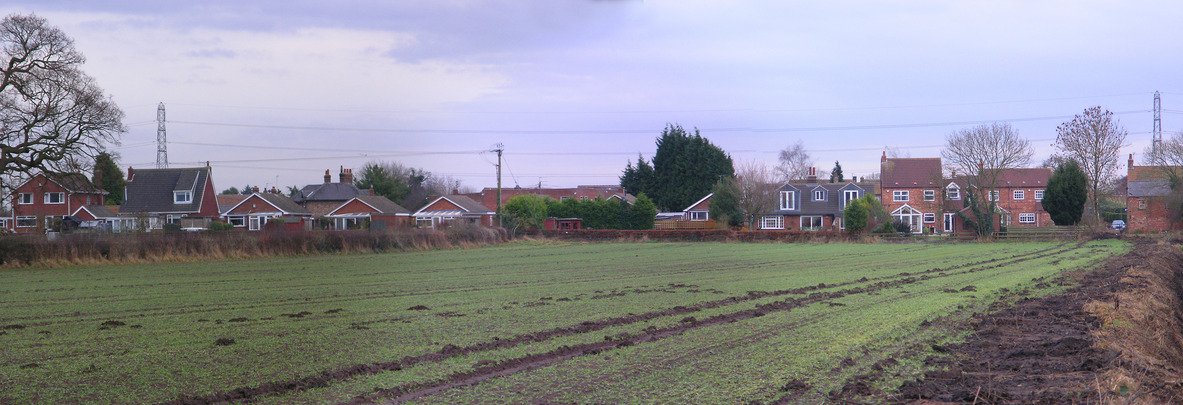 The houses at the edge of the field, seen from the point
