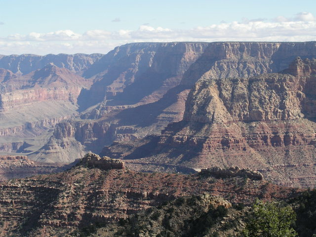 Remnants of Coconino Sandstone resemble two ships in a line.  Barely visible on the horizon is the famous Grand Canyon Desert View Watchtower.