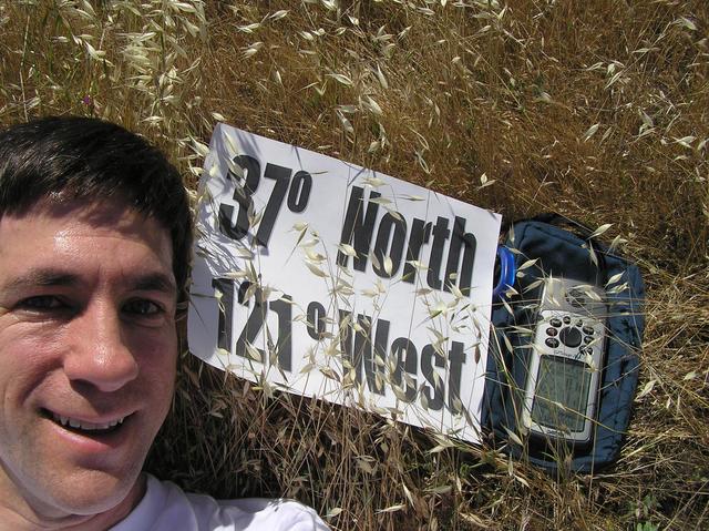 Joseph Kerski lying in California's golden fields on 37 North 121 West.