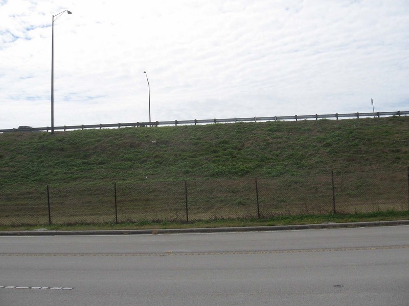 View south across the frontage road to the freeway beyond the embankment.