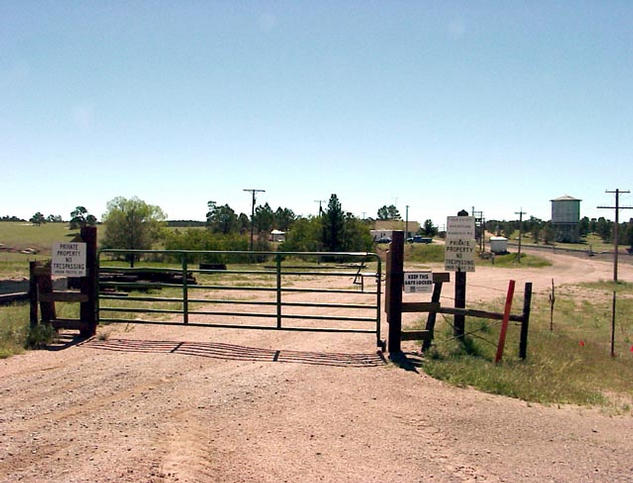The gate blocking the dirt road along the Union Pacific railroad tracks.