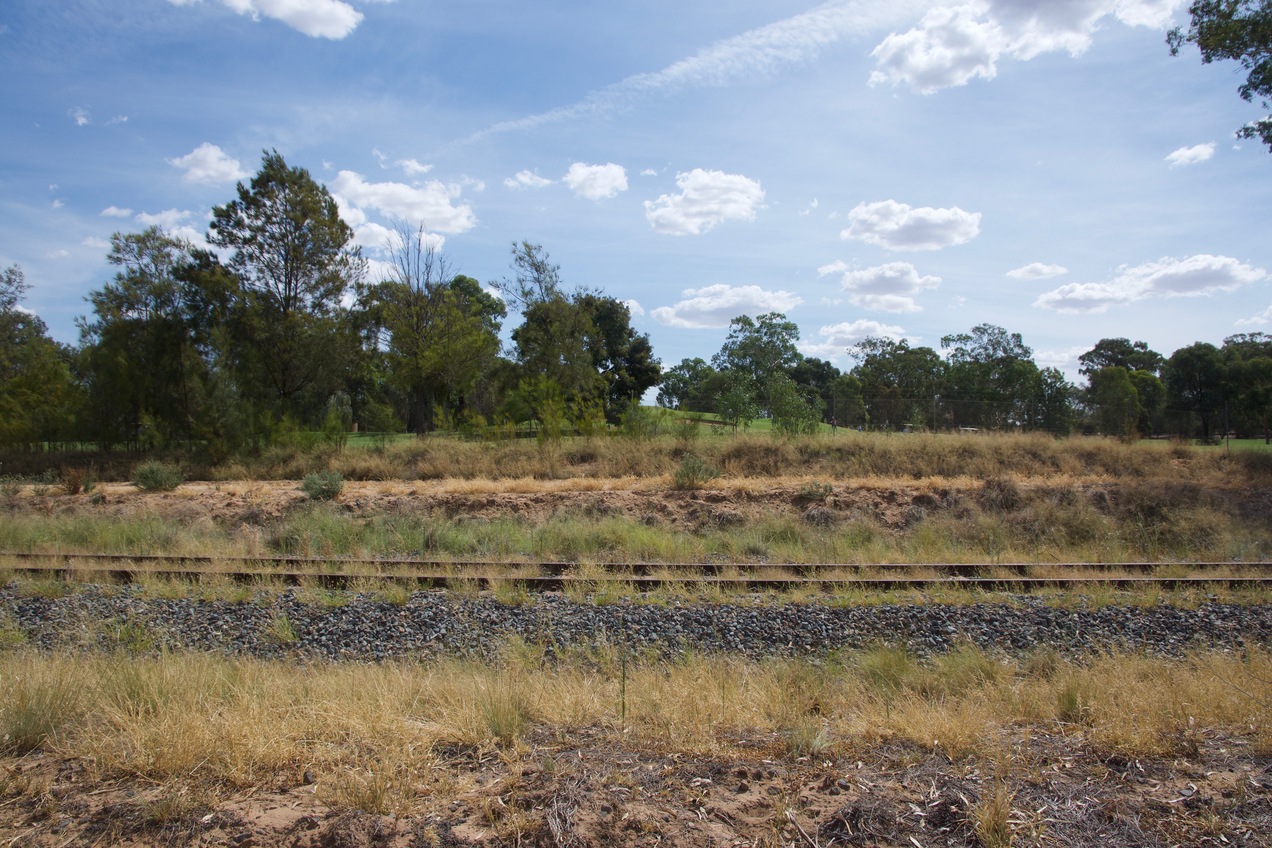 View West (across railroad tracks towards an adjacent golf course, from 37 m West of the point)