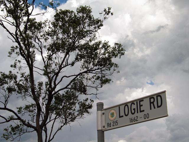 The sign for the unsealed road, and the storm approaching the in the background.