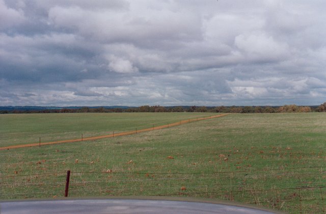 The track beside the fenceline towards the confluence.  See the thunderclouds!