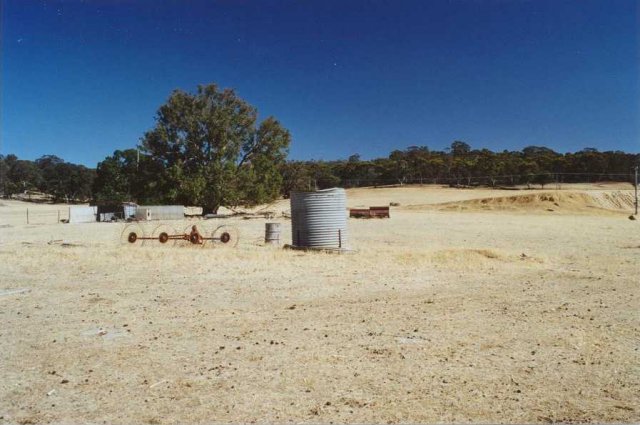 Looking north with redundant farm implements and dam on the right.