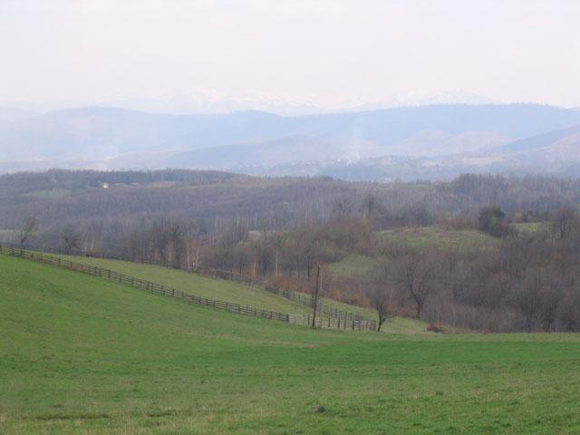 View south from the car: the confluence 180 m down the hill. Snow capped Mount Bjelašnica on the horizon.