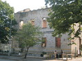 #3: Life goes on: Men converse in front of bullet-holed building in Mostar