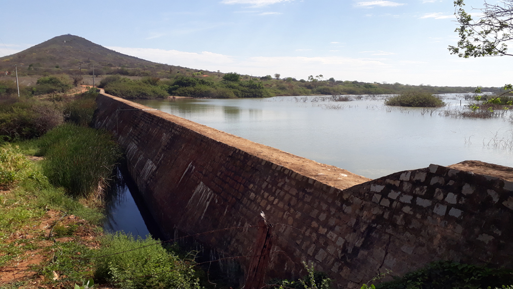 A estrada de terra passa por uma barragem - the dirt road passes by a dam