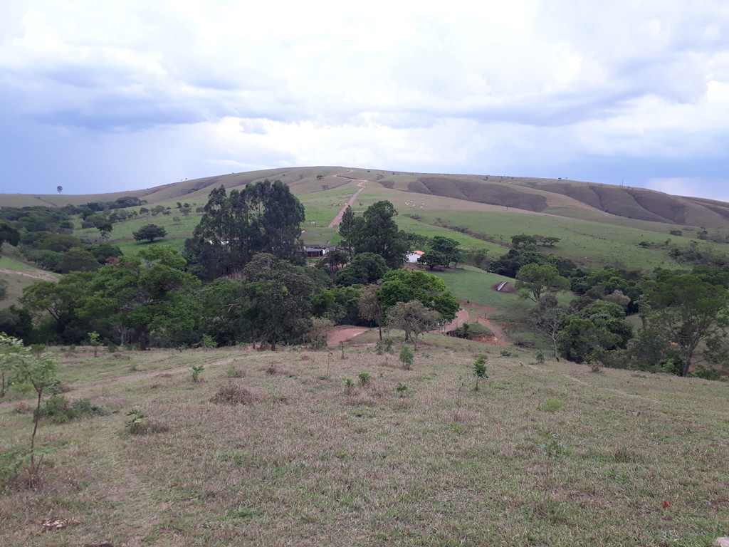 Olhando para trás na parte final da caminhada: a sede da fazenda e a estrada que sobe a montanha - looking back near the end of the hiking: the farmhouse and the road that climbs the mountain