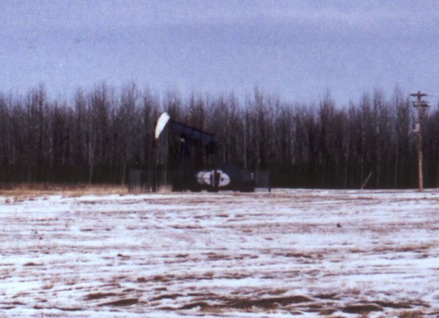 An oil well, at the north end of the hay field.