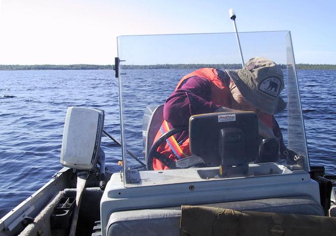 At 46N 66W. Looking South from the confluence point.  Crouching is Gil Pelletier local proprietor of the Black Bear Lodge, owner/driver of the boat.  The photo has been edited to make the horizon horizontal.