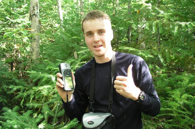 Martin Roy avec son GPS dans la main à l'endroit exacte de la confluence. / Martin Roy with his GPS in his hands at the confluence.