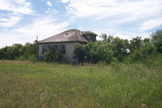 Abandoned one room school house beside the church.