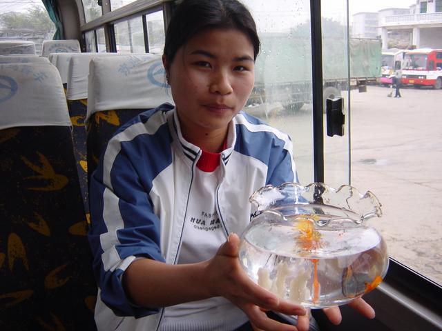 Girl with goldfish bowl on the bus from Nanning to Nalong