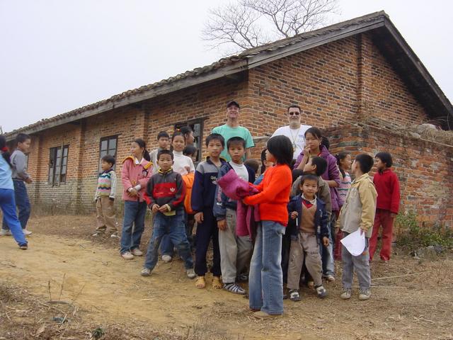 Facing east, with everyone standing on the confluence, at the corner of the brick building