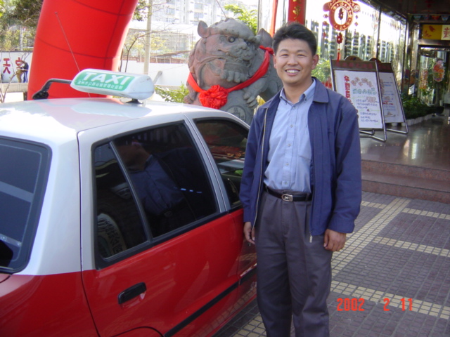 The taxi driver who took me from Zhangzhou to Longyan, outside the entrance to the Houston Hotel