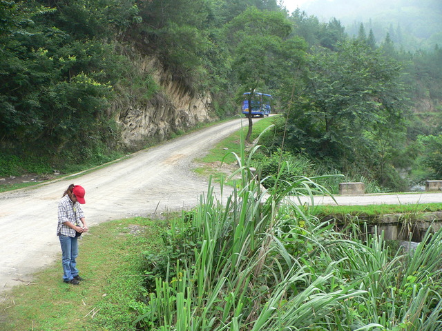 Ah Feng at the Kēngdòng turnoff, as the Lípíng bus disappears down the main road.