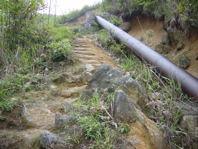 Pipe channelling water to the power plant below, with steep path running up beside it