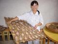 #9: Pyjama-clad guesthouse proprietress proudly displaying dried fish