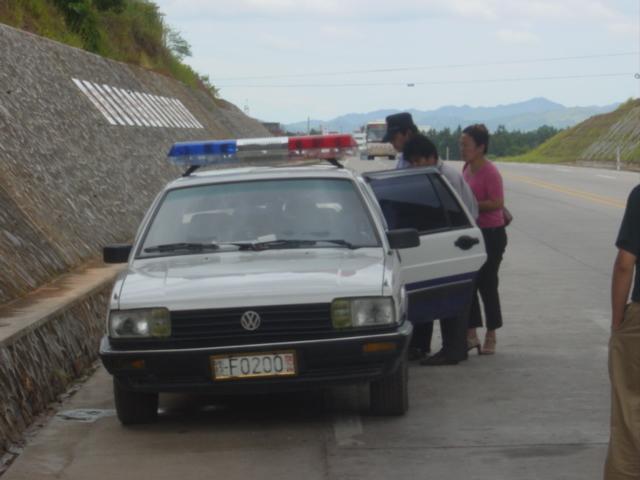 Bus driver (left front) and ticket seller (right) in discussions with police regarding overloading