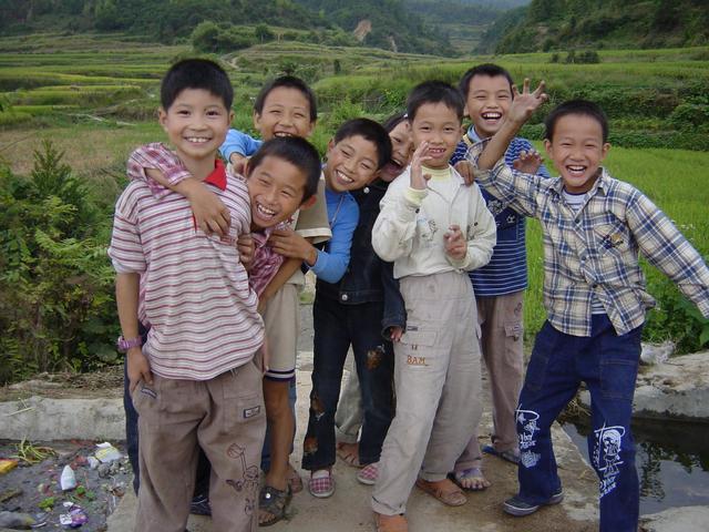 Children on small bridge over stream near Niankeng Village, with confluence point in distance behind them