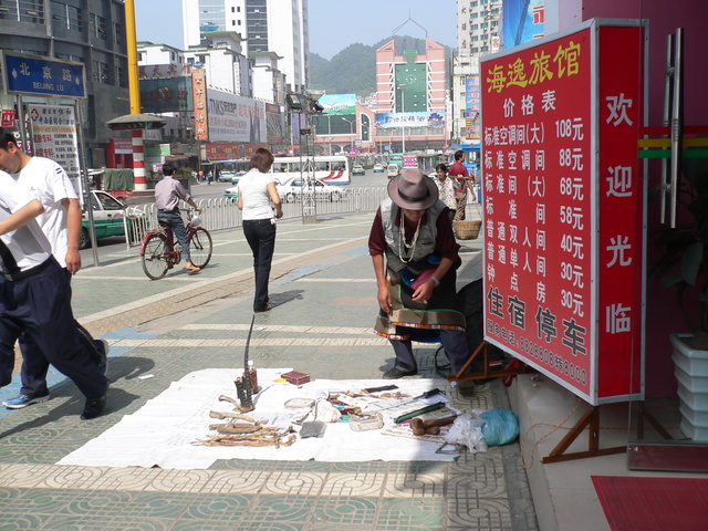 Man selling animal parts on a street in Zūnyì.