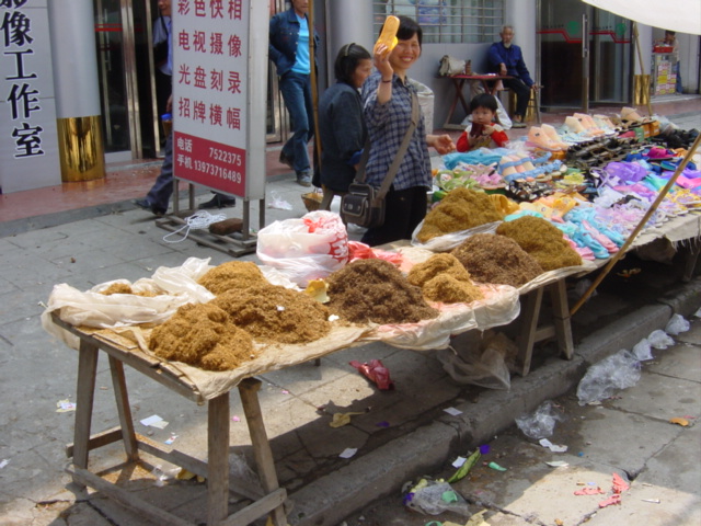 Plastic shoe stall alongside a tobacco stall in Pingkou
