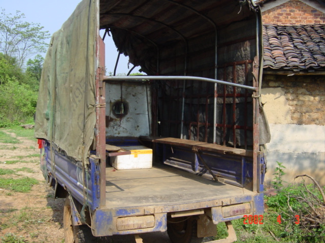 Wooden planks made uncomfortable seats in the back of this three-wheeled truck