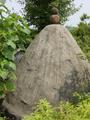 #10: Two brown boulders seemingly precariously balanced atop one of the graves