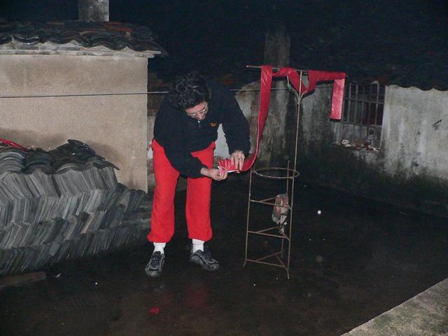 Tony setting off firecrackers at midnight on the roof in the rain