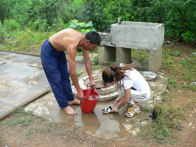 Local assists Ah Feng to clean mud from shoes and feet.