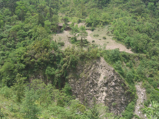 #1: House on the cliffside on the other side of the valley from where this confluence lies.  This picture was taken about 50 meters from the confluence point just outside of the trees.