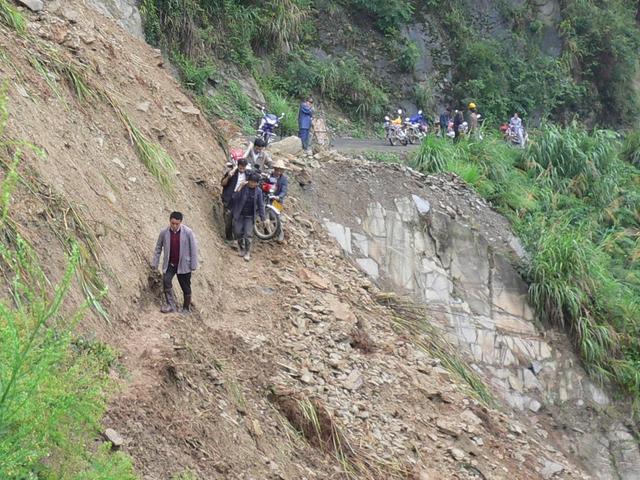 Death-defying portage at scene of another landslide on road from Zhushan to Guandu.