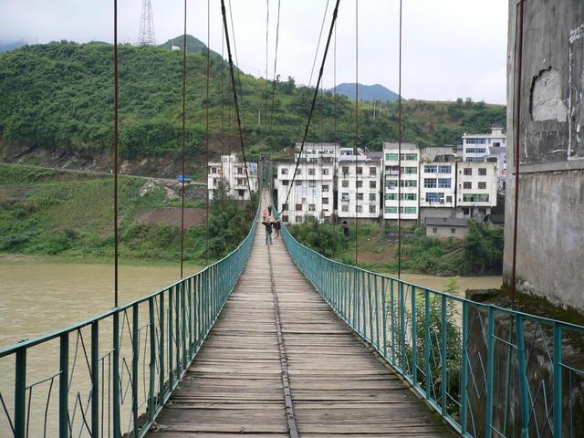 Targ on pedestrian suspension bridge with Guandu behind.