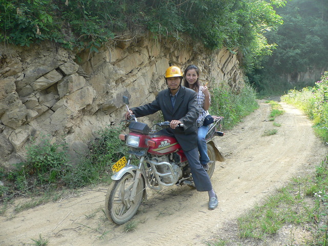 Motorcyclist and Ah Feng on the dirt road.