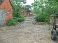 #6: Muddy dirt road passing through village.