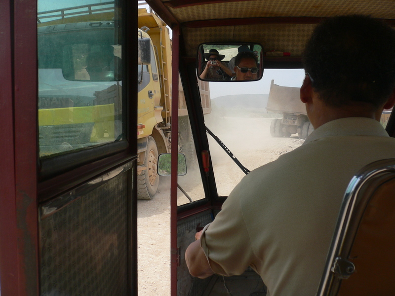 Our three-wheeler dodging trucks loaded with rocks and gravel