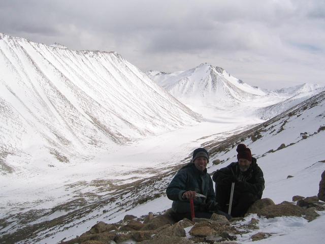 Greg and Robert enjoying success and holding ice axes with U-valley in background.